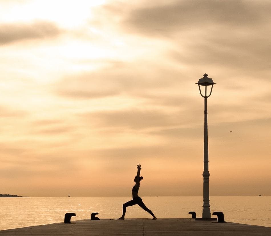 Silhouette en posture de yoga au coucher du soleil