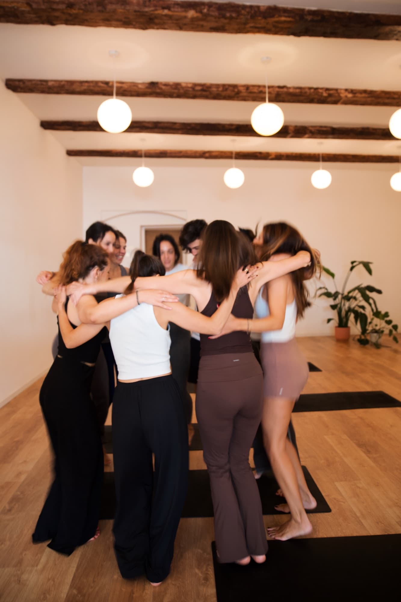 Des élèves enlacées en cercle dans le studio
